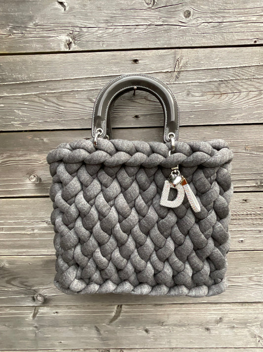 Eine gestrickte Tasche in Grau mit Henkel und Tasche 