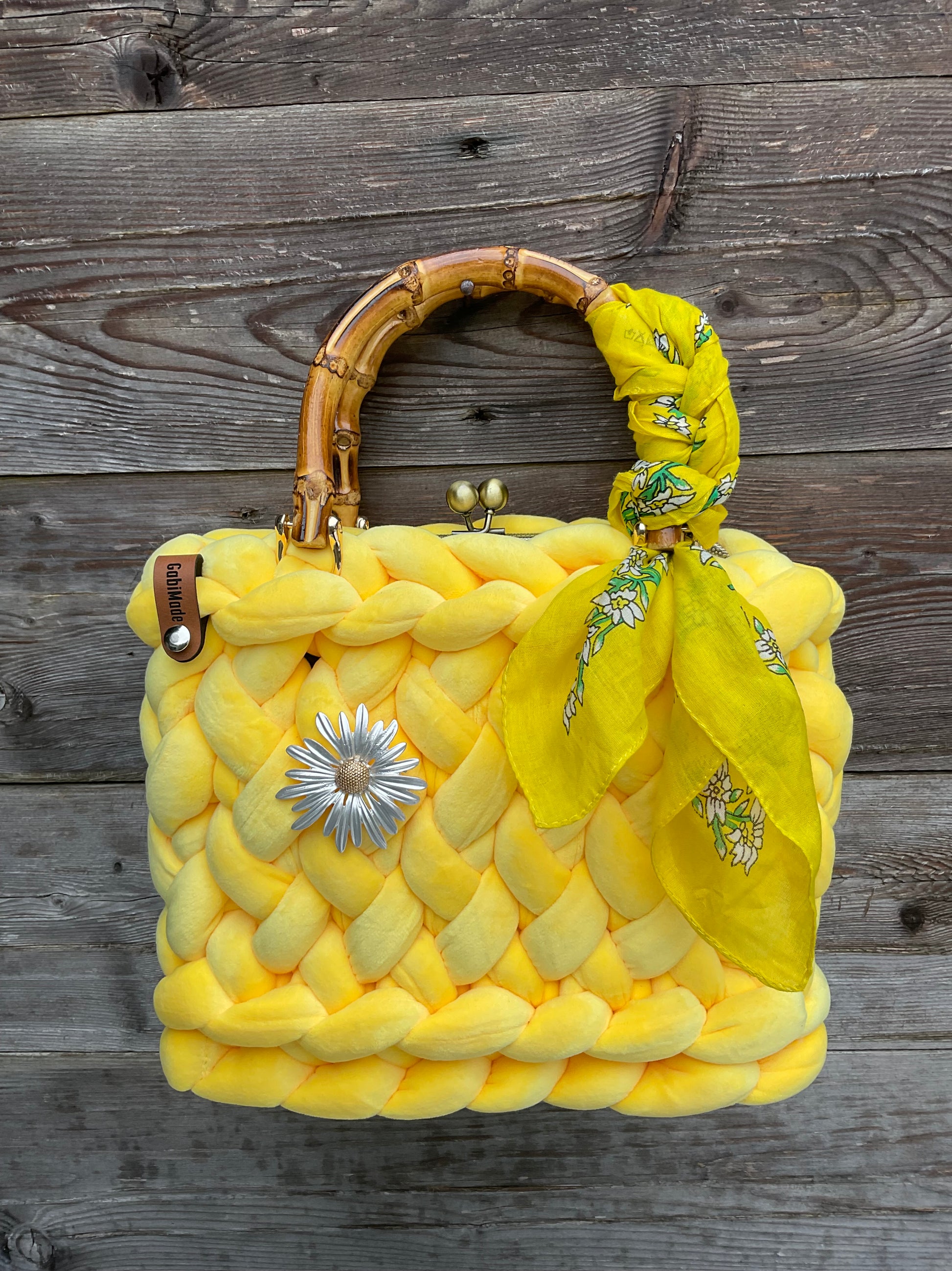 Eine gestrickte gelbe trachtentasche mit Brosche und Tuch 