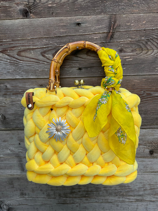 Eine gestrickte gelbe trachtentasche mit Brosche und Tuch 