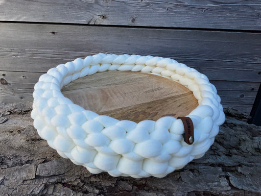 Ein gestricktes Cremeweißes Tablett mit Holzplatte 