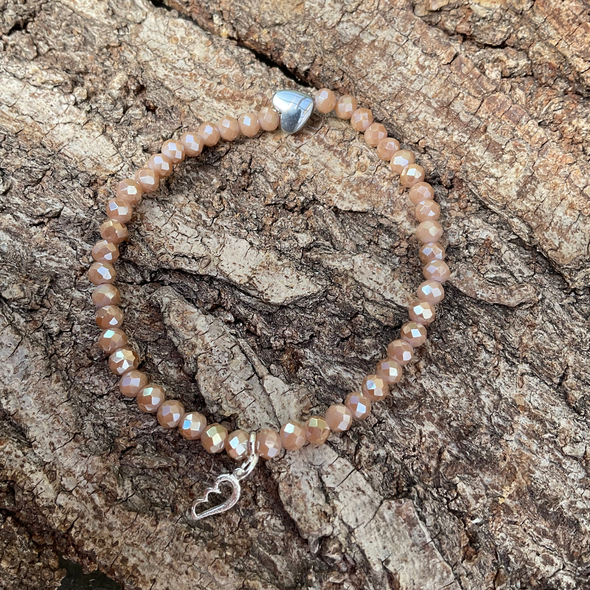 Ein Perlenarmband in Taupe mit Flügelanhänger 