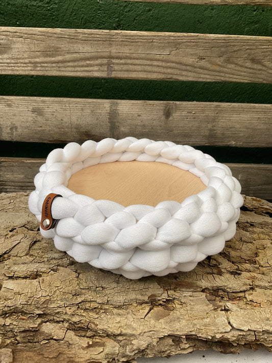 Ein gestricktes weißes Tablett mit Holzteller 