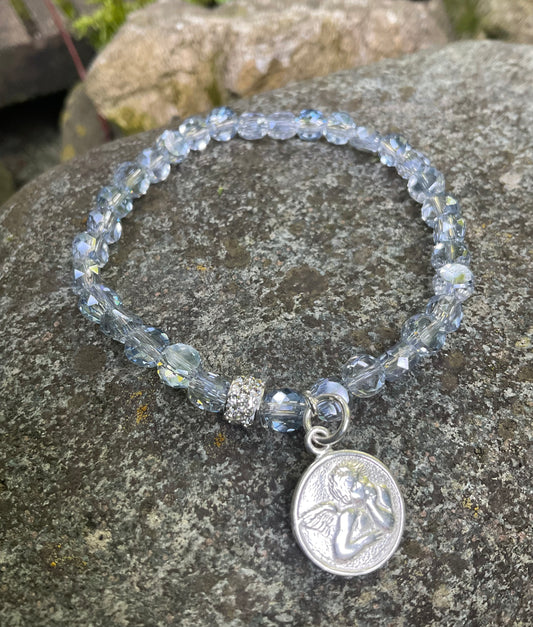 Ein Armband aus hellblauen Perlen mit Schutzengel Anhänger 