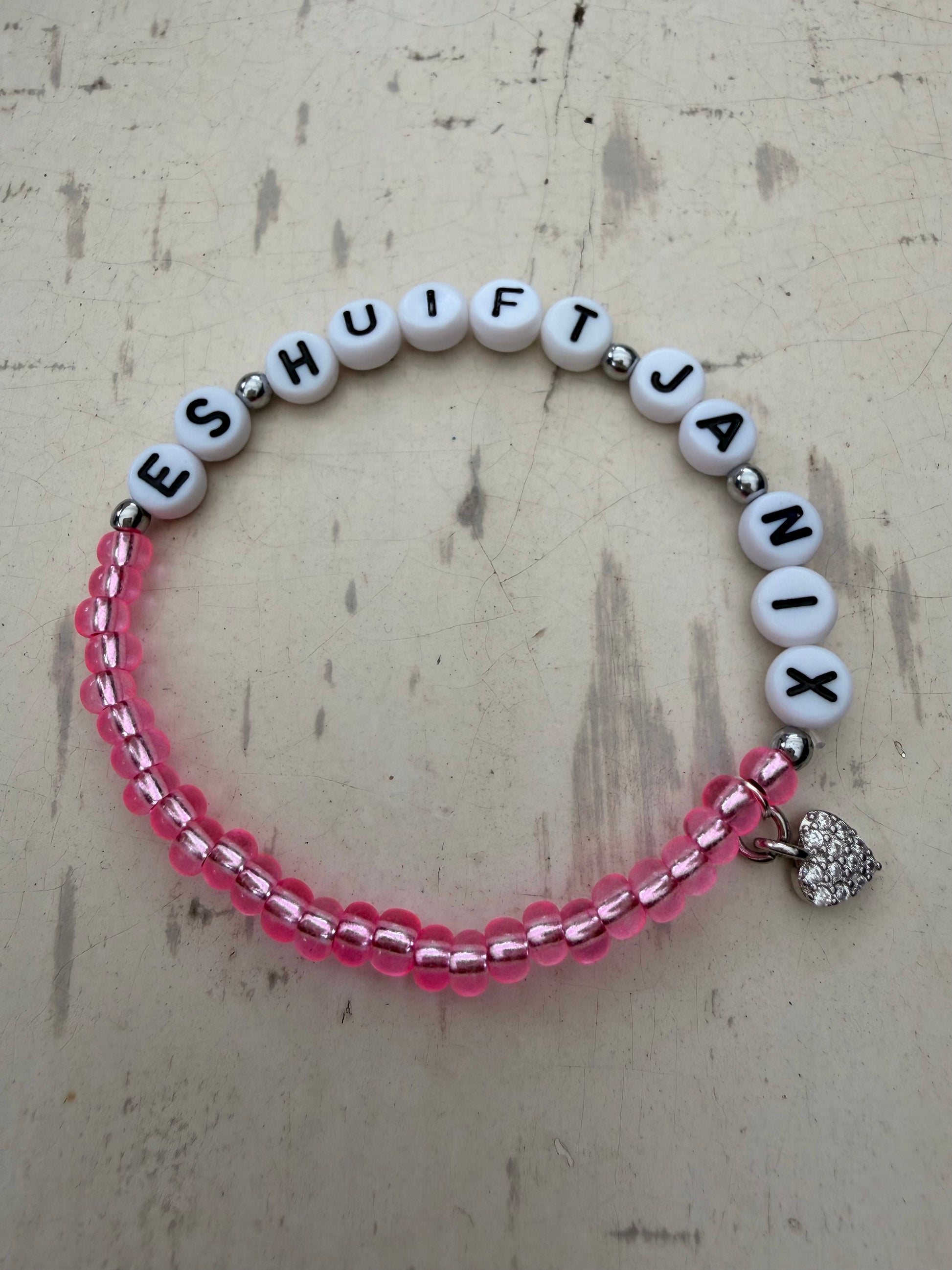 Ein pinkes Perlenarmband mit es huift ja nix