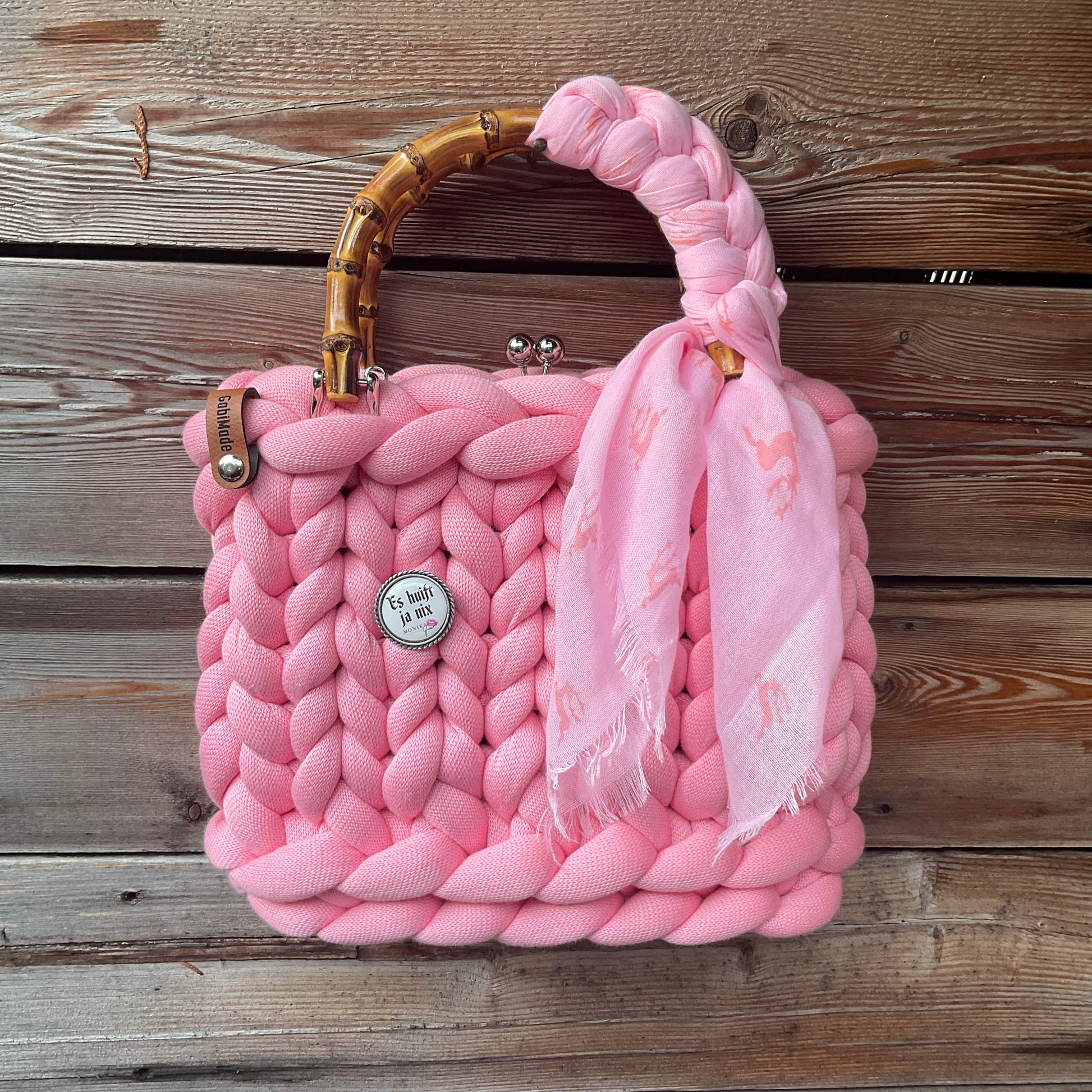Eine rosa Trachtentasche mit Gaudiknopf und Tuch 