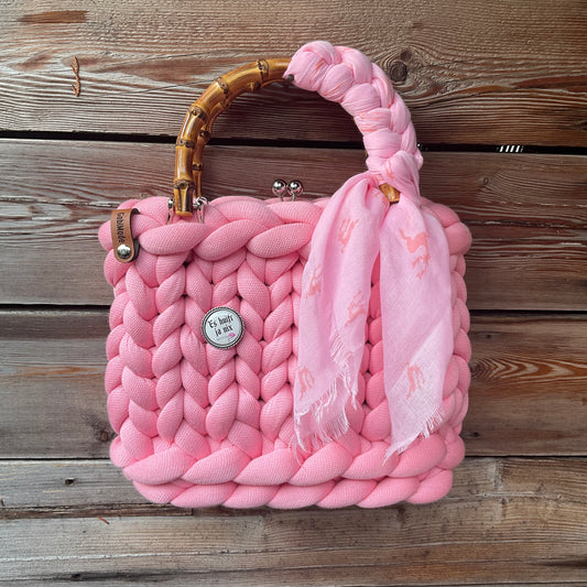 Eine rosa Trachtentasche mit Gaudiknopf und Tuch 