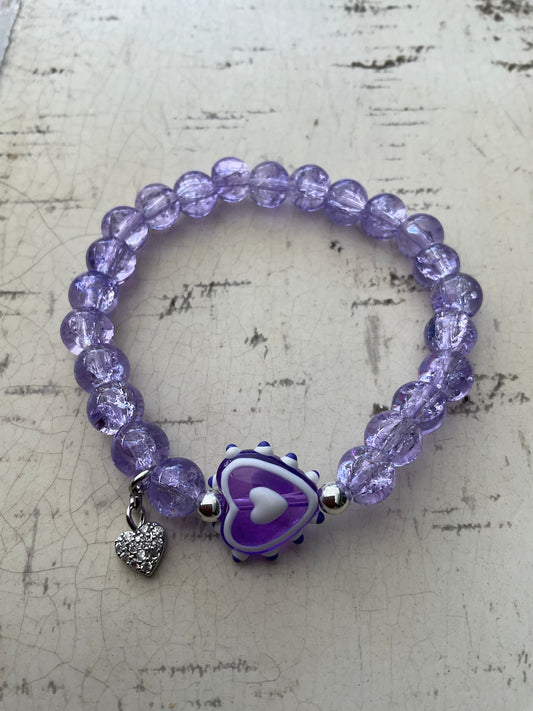 Ein violettes perlenarmband mit Herzperle 