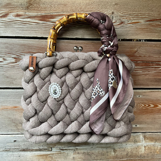 Eine gestrickte braune Trachtentasche mit Tuch und Bambusgriffen 
