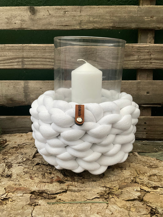 Ein weißes gestricktes Windlicht mit Glaseinsatz 