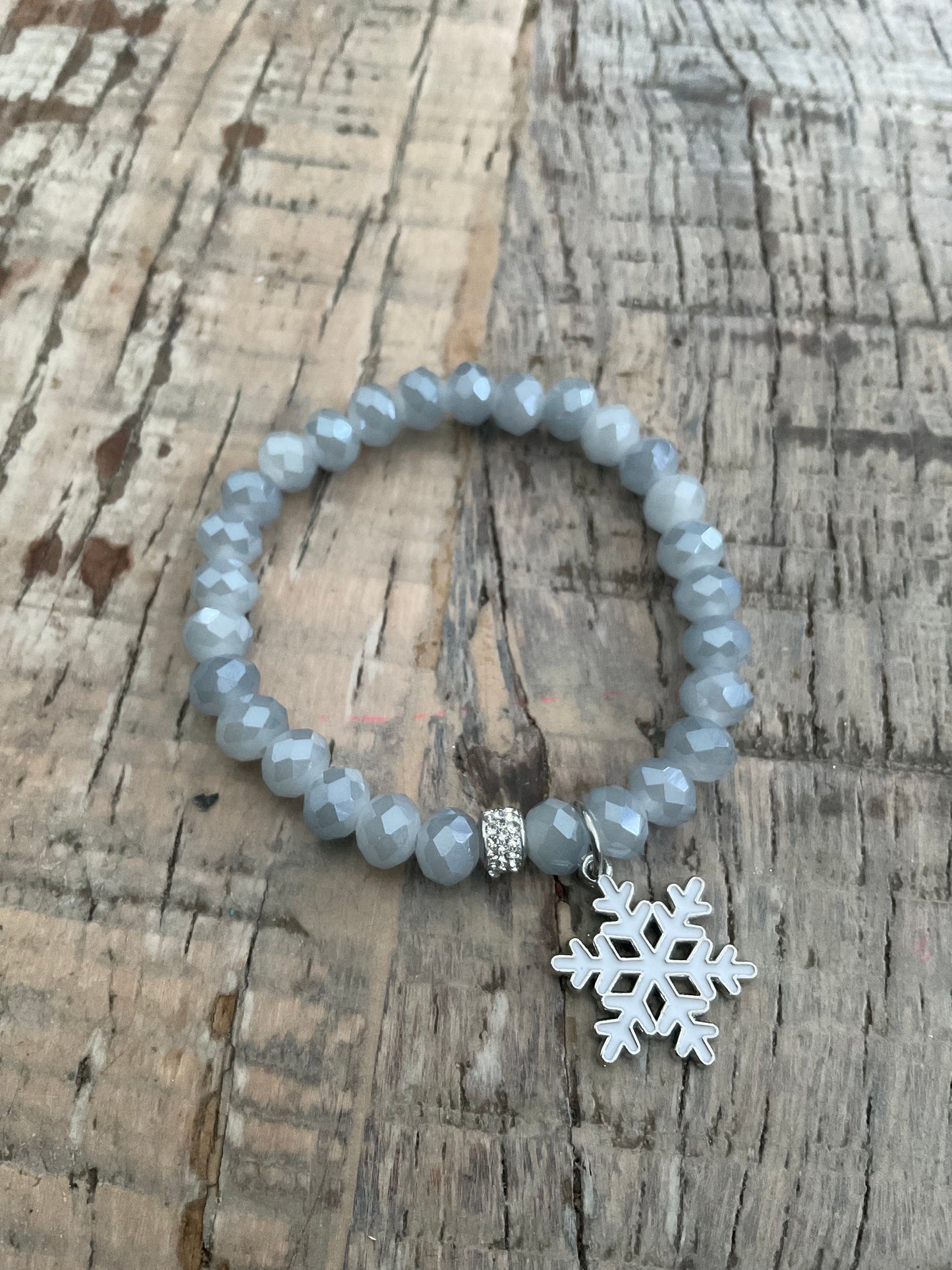 Ein Perlenarmband mit einem Schneeflocken Anhänger 