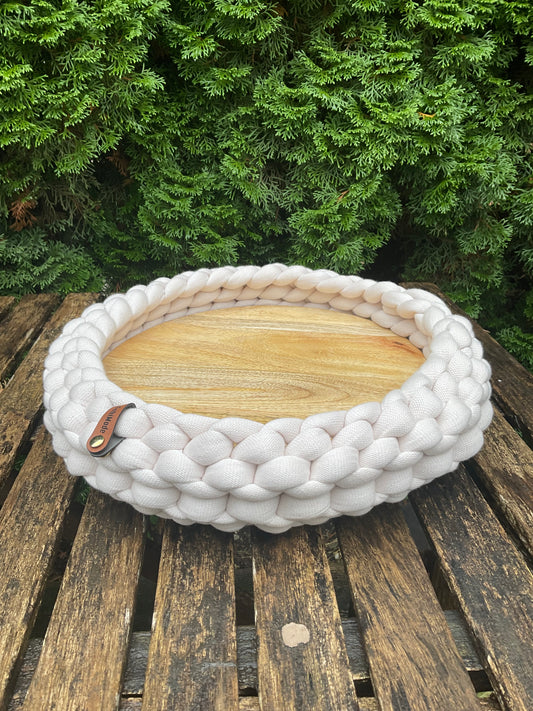 Ein gestricktes Beiges Tablett mit Holzbrett