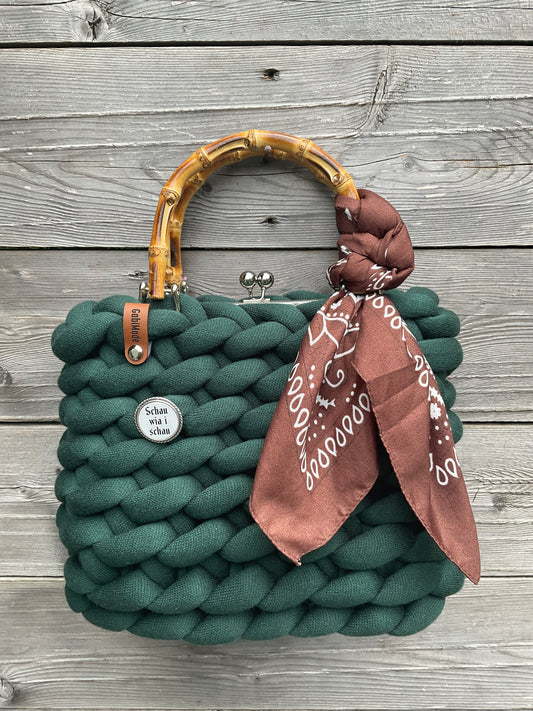 Eine dunkelgrüne gestrickte Trachtentasche