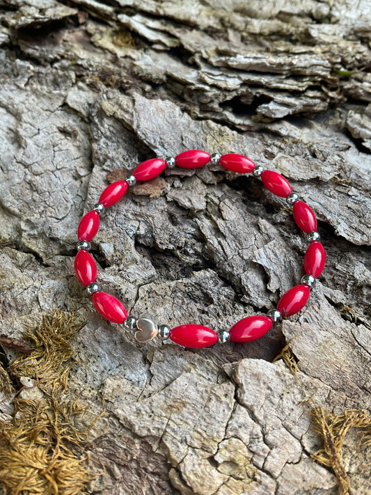 Ein rotes Perlenarmband mit einem Silberherz