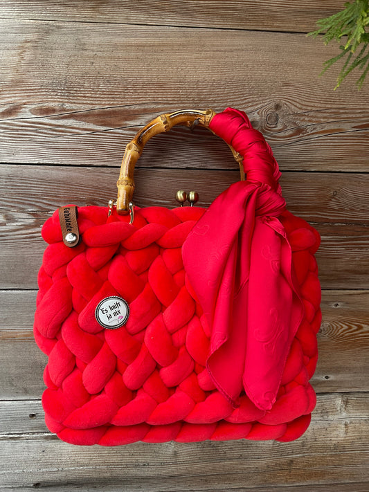 Eine gestrickte trachtentasche mit Brosche und Tuch 