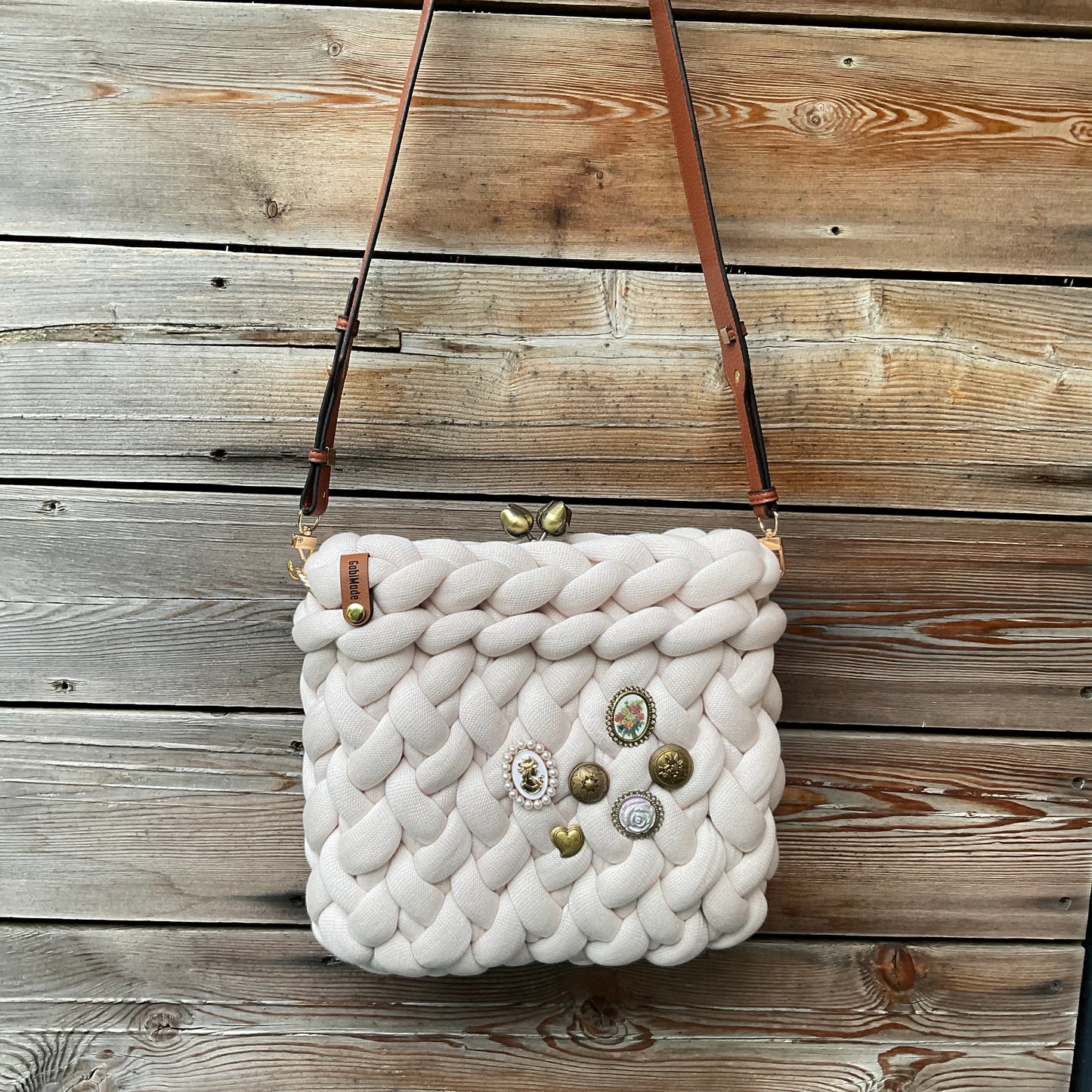 Eine gestrickte cremefarbene croccbody Tasche 