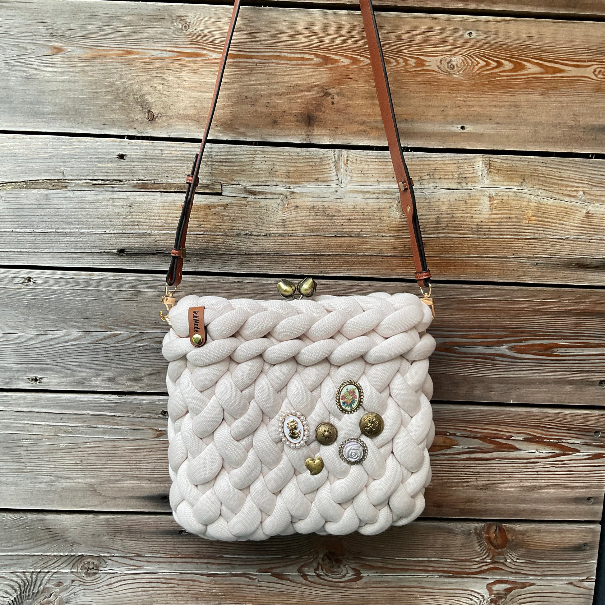 Eine gestrickte cremefarbene croccbody Tasche 