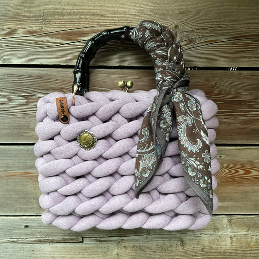 Eine gestrickte fliederfarbene Trachtentasche mit Tuch und Bambusgriffen 