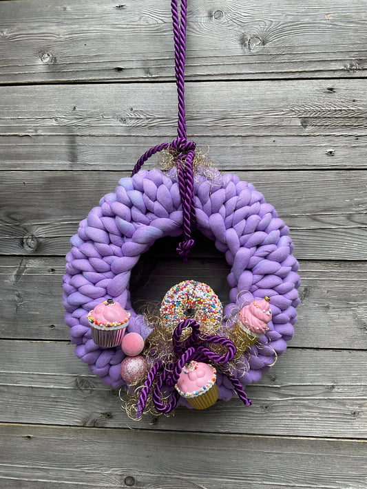 Ein gestrickter dekorierter Kranz in lila 
