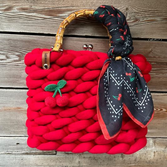 Eine gestrickte rote Trachtentasche mit Tuch und Bambusgriffen 