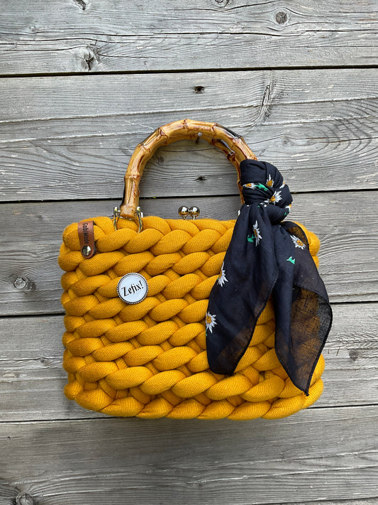 Eine gestrickte safranfarbene Tasche mit Tuch 