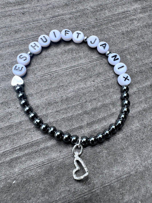 Ein graues Perlenarmband mit Herz und „Es huift ja nix“