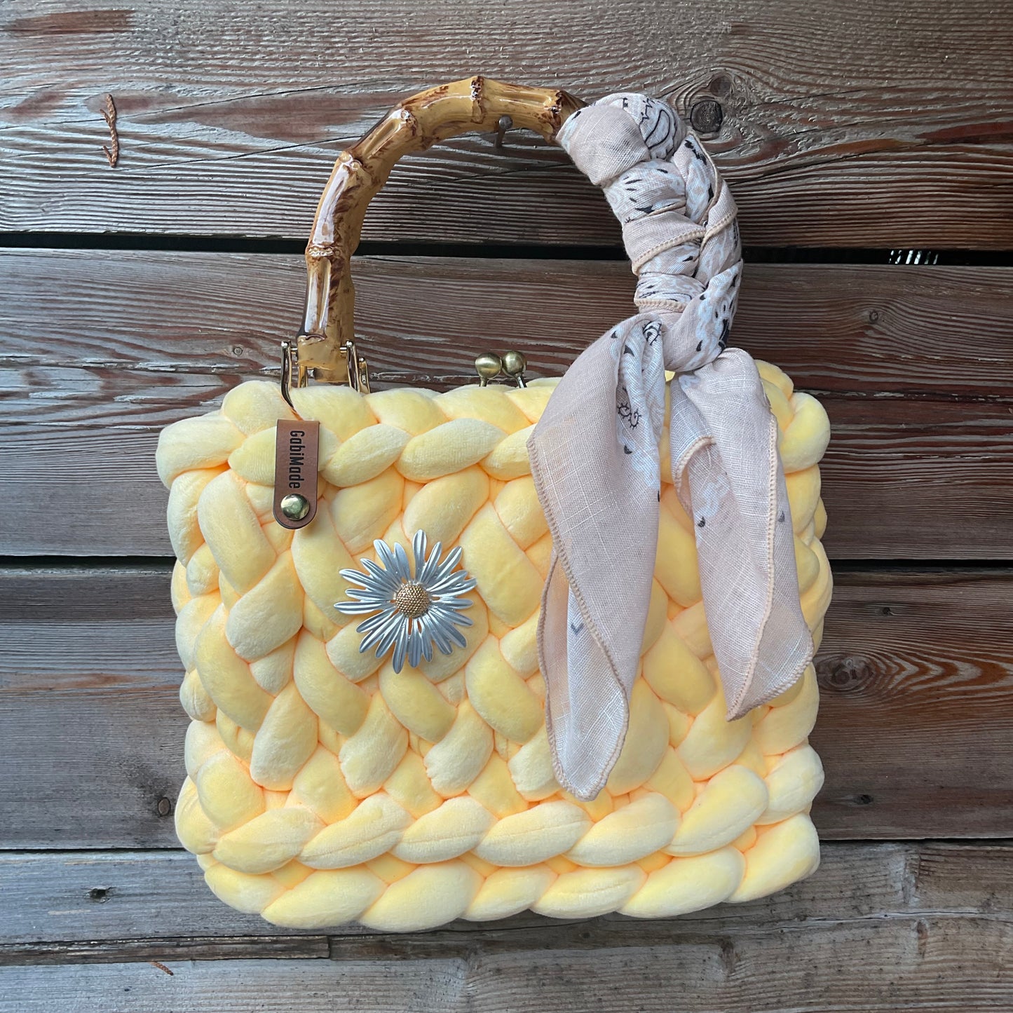 Eine gestrickte gelbe Trachtentasche mit Brosche und Tuch 