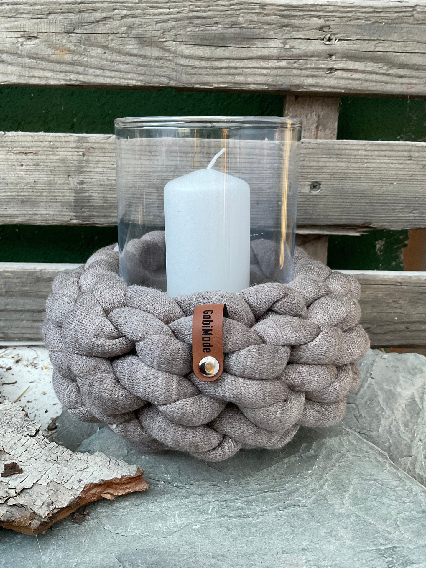 Ein gestricktes Taupe farbenens Windlicht mit Glaseinsatz und Kerze 