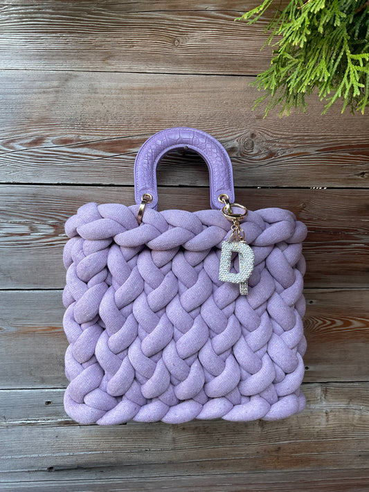 Eine gestrickte lila Tasche mir Henkel und Anhänger 