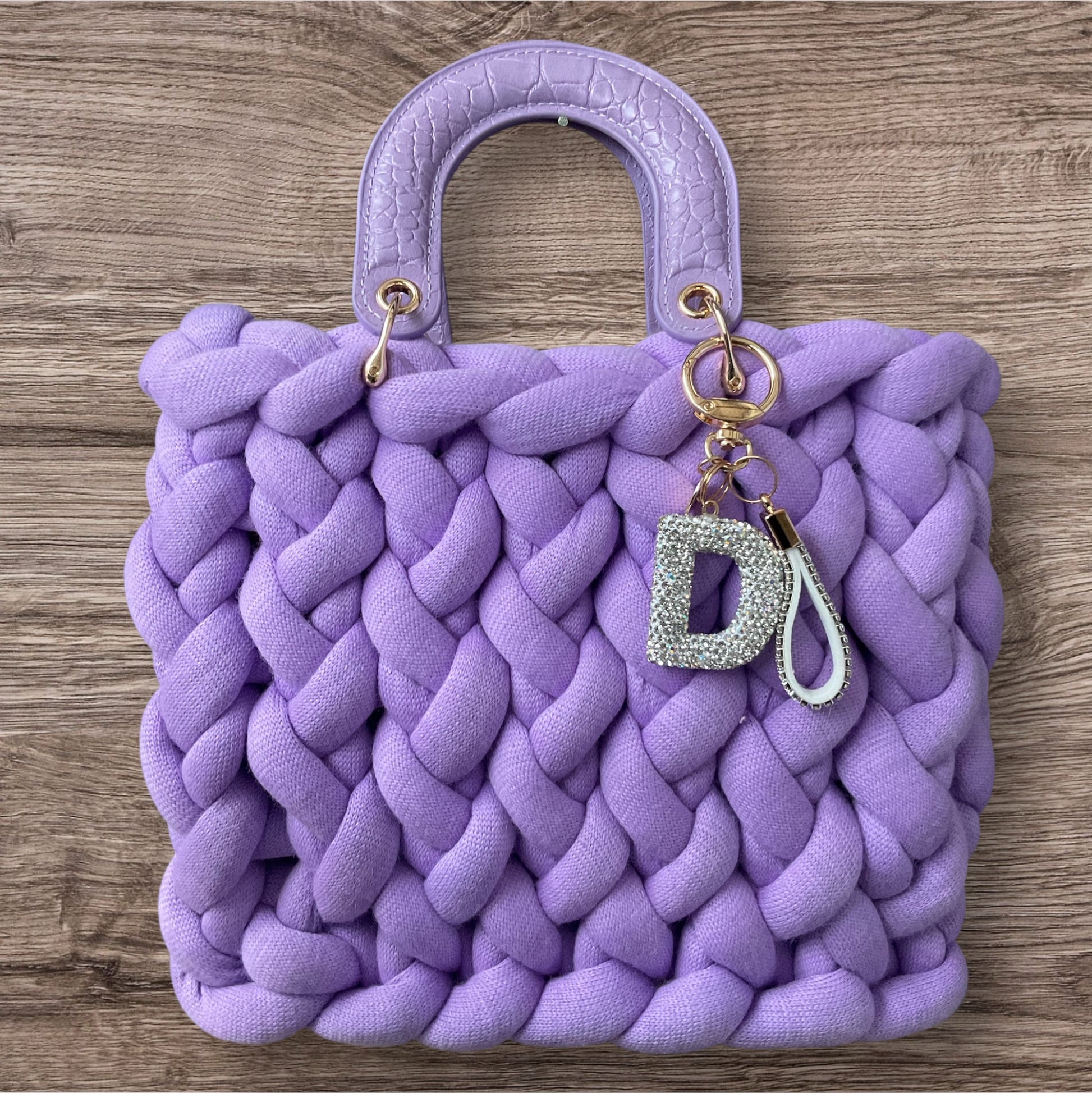 Eine gestrickte Tasche in lila mit Henkel 