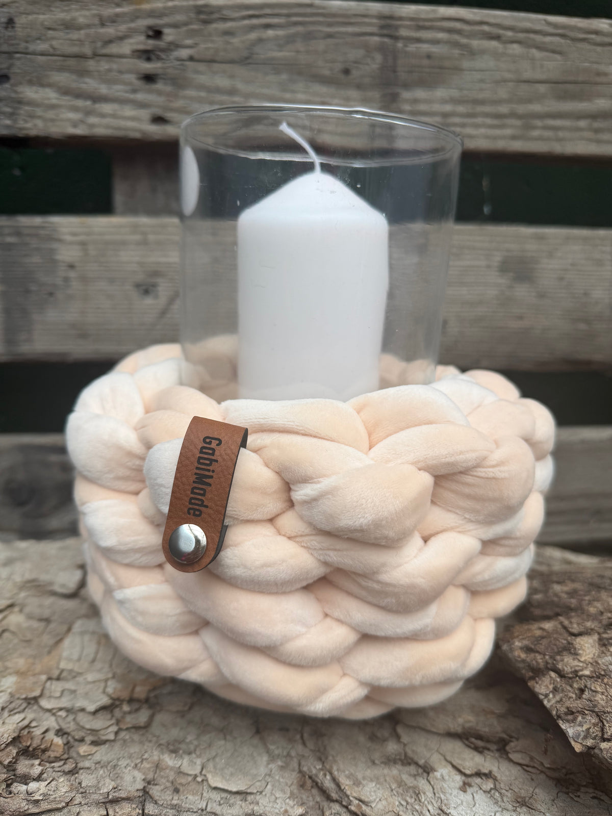 Ein gestricktes cremefarbenes Windlicht mit Glaseinsatz 