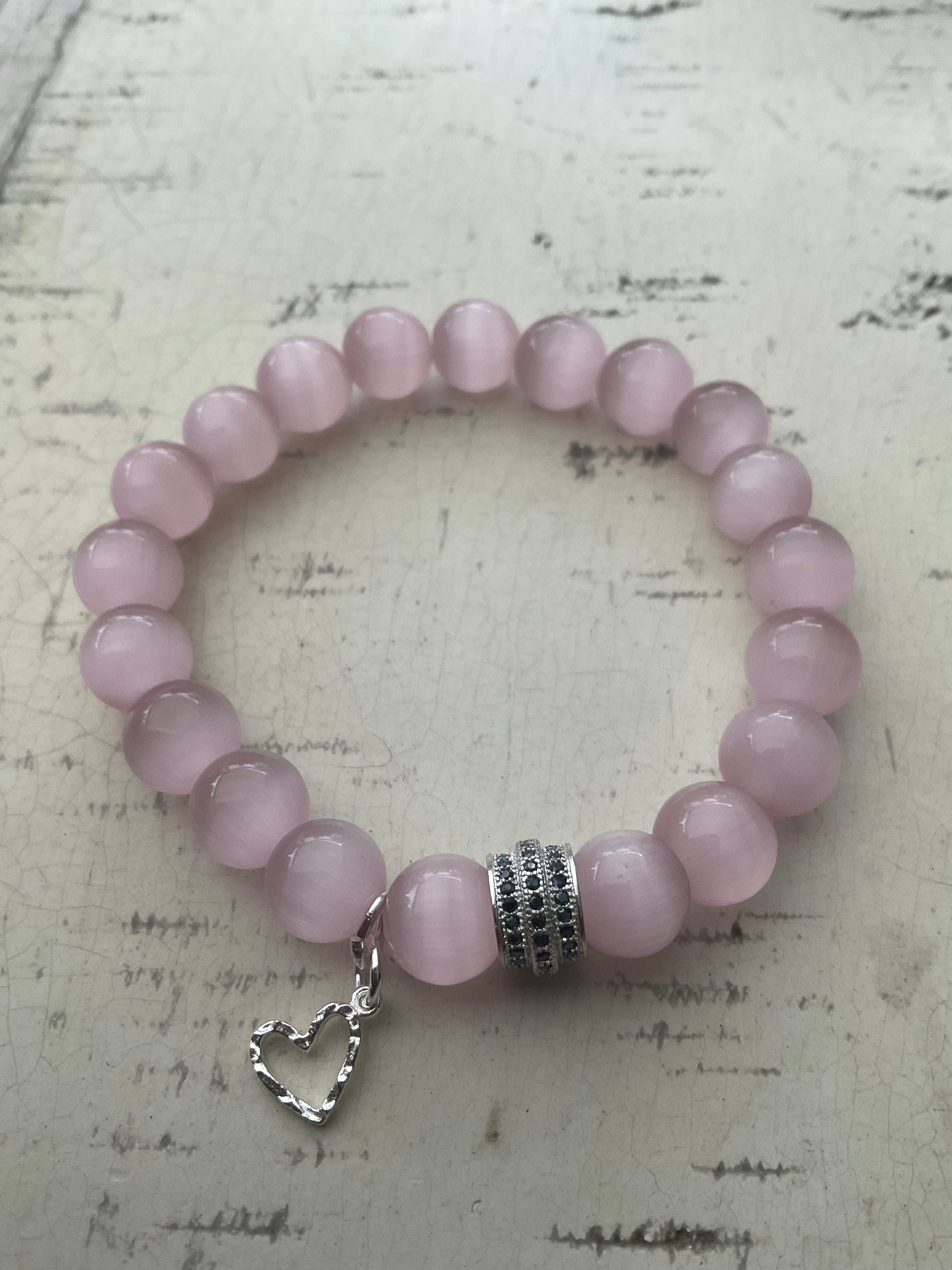 Ein rosa Perlenarmband mit Herzanhänger 