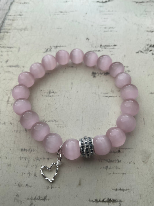 Ein rosa Perlenarmband mit Herzanhänger 
