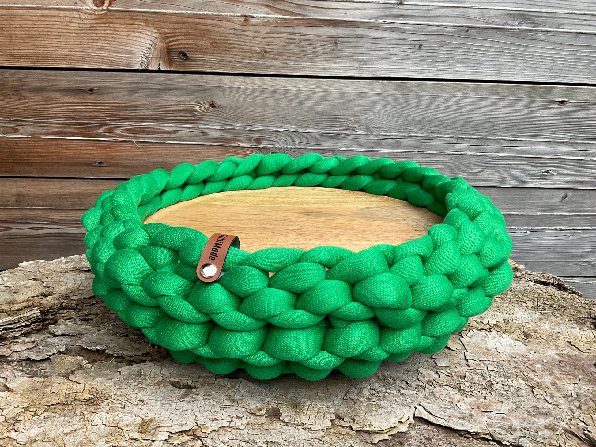 Ein gestricktes grünes Tablett mit Holzplatte