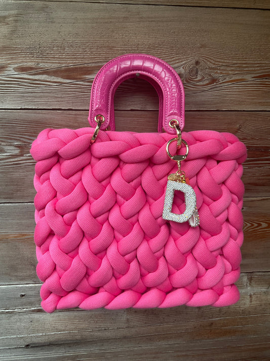 Eine Pinke gestrickte Tasche mit Henkeln 