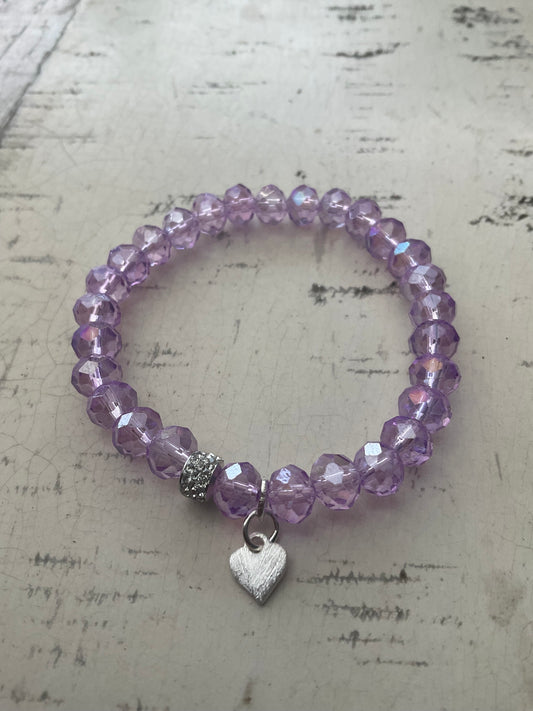 Ein lila perlenarmband mit Herzanhänger 