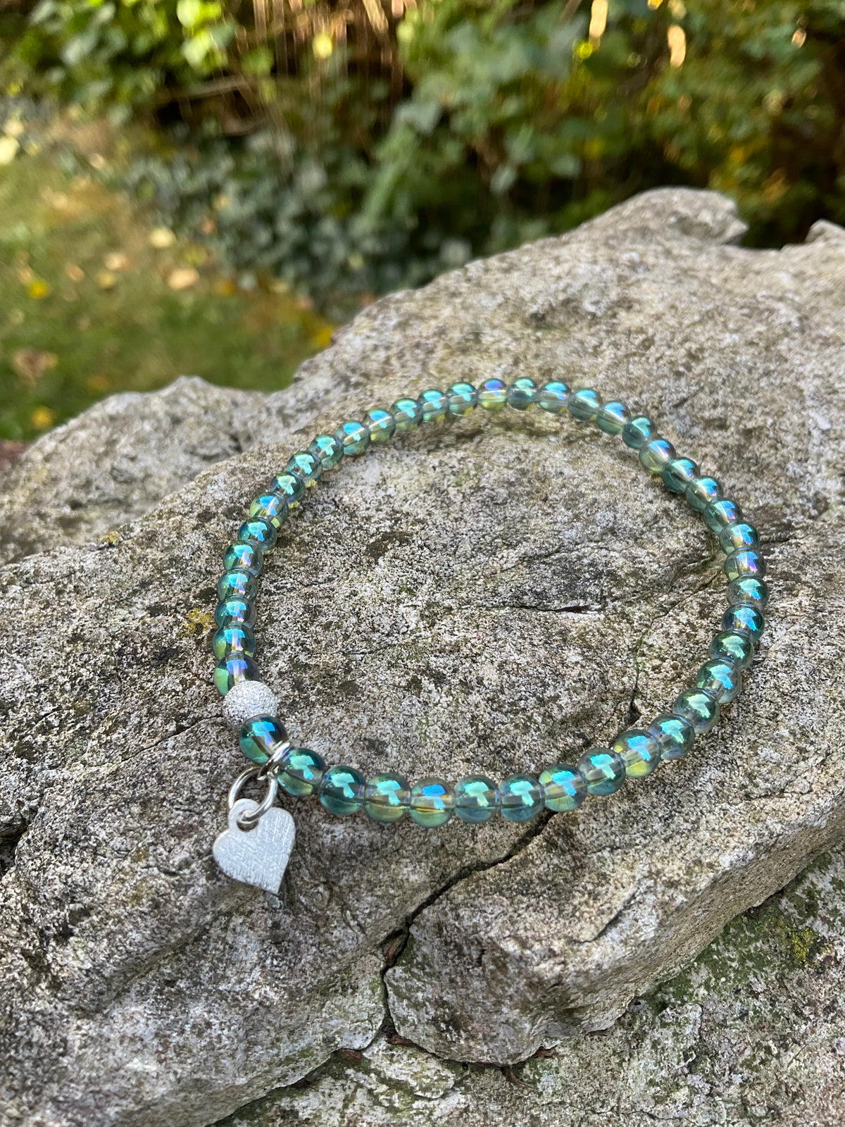 Ein Aqua Aura Armband mit Herzanhänger 