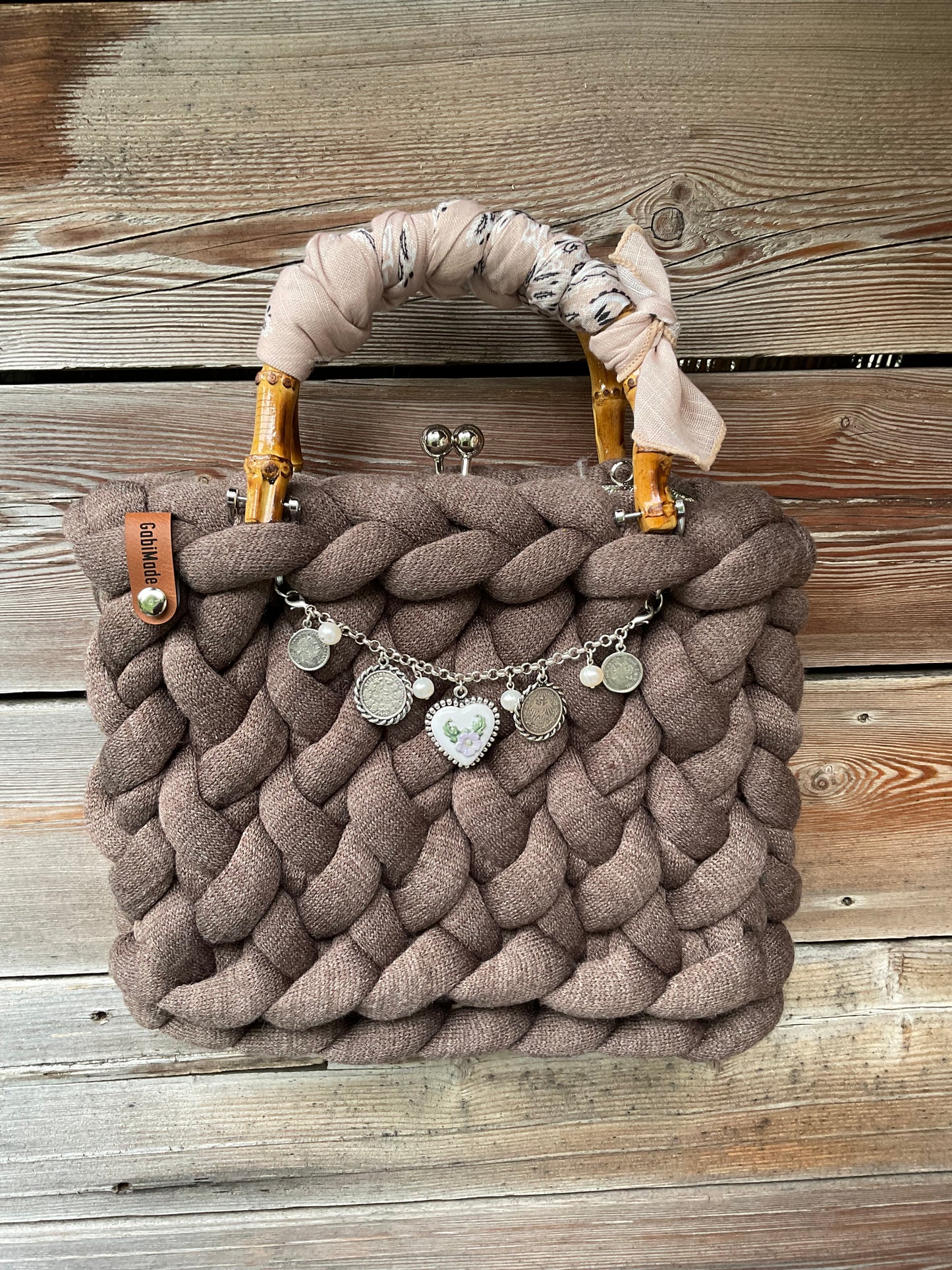 Eine gestrickte braune Trachtentasche mit Charivari und Bambusgriffen 