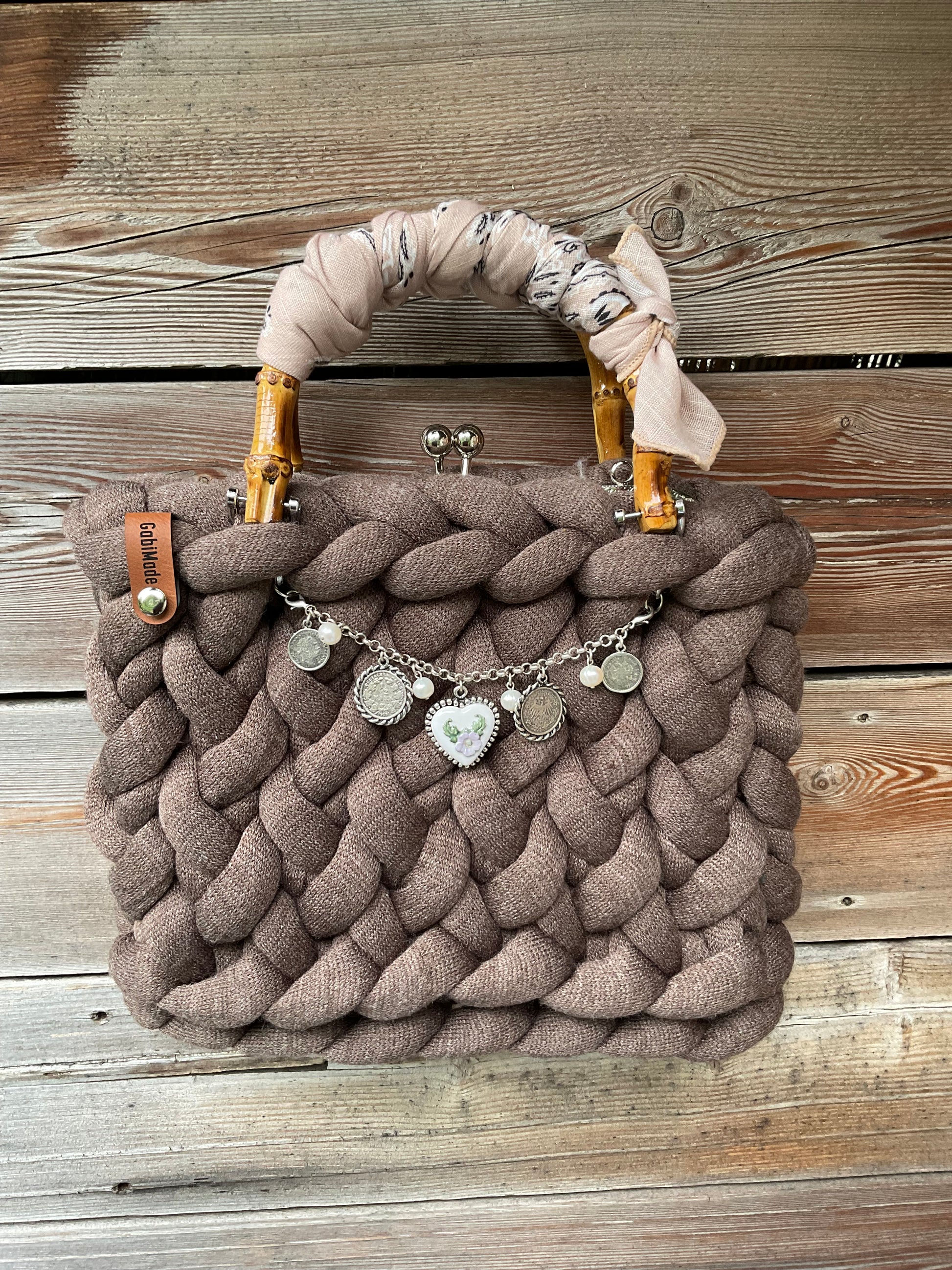 Eine gestrickte braune Trachtentasche mit Charivari und Bambusgriffen 