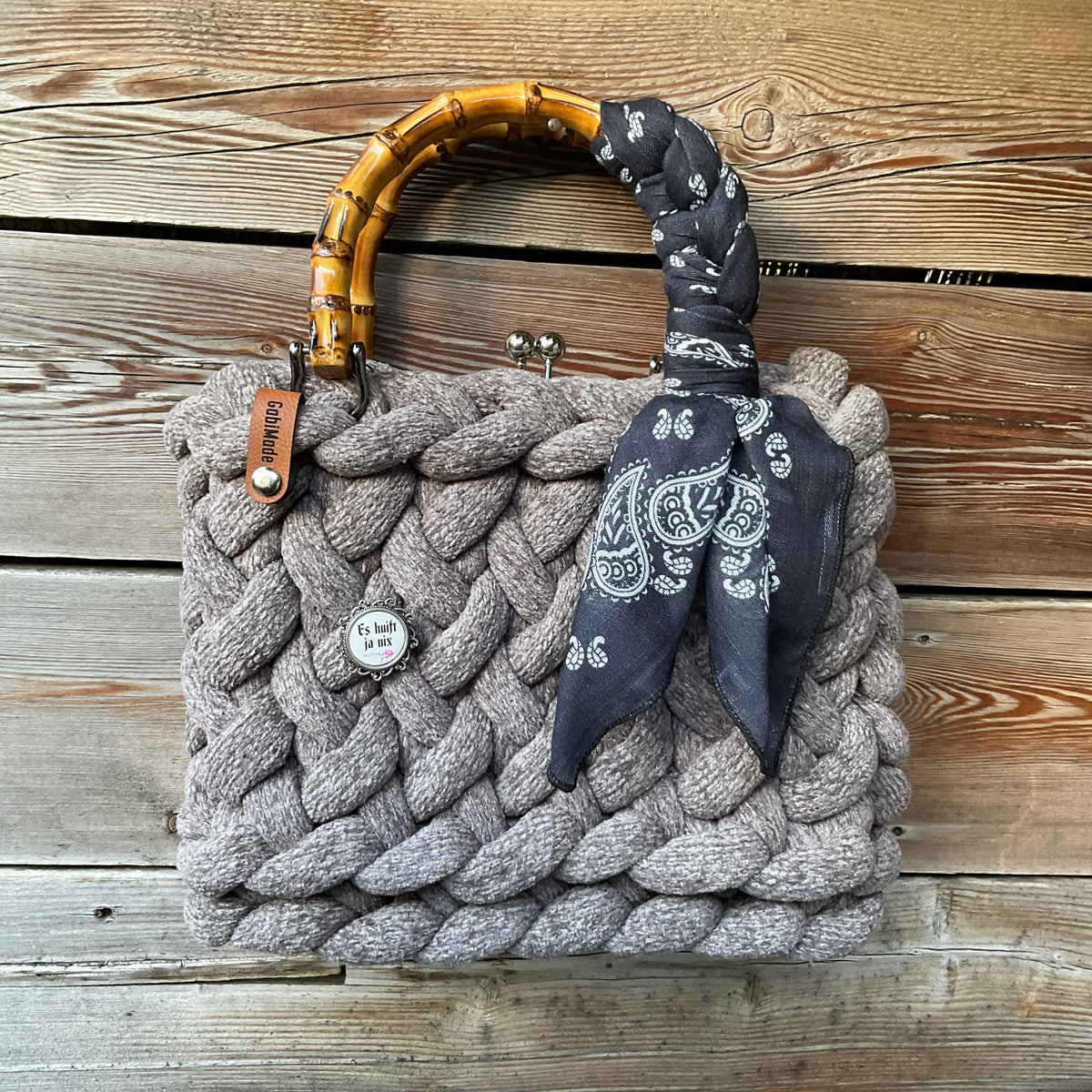 Eine gestrickte graue Trachtentasche mit Tuch und Bambusgriffen 