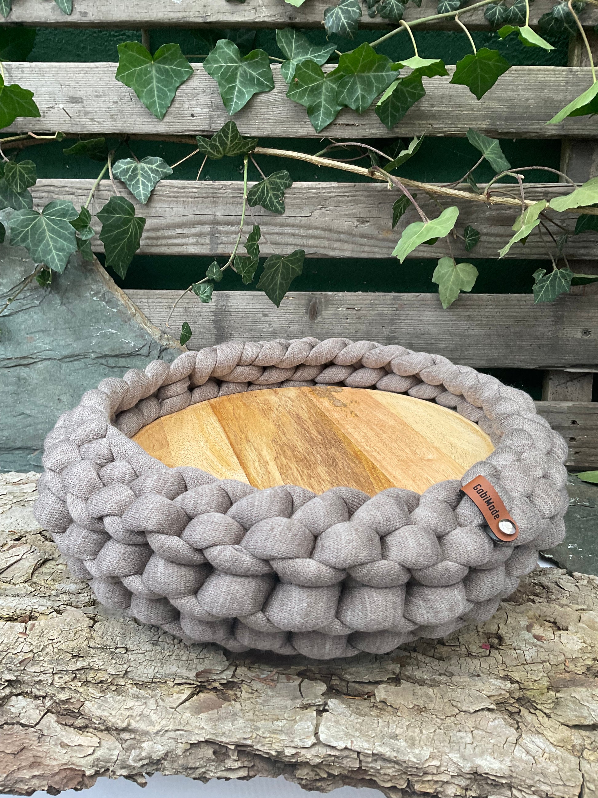 Ein gestricktes Hellbraunes Tablett mit Holzteller 