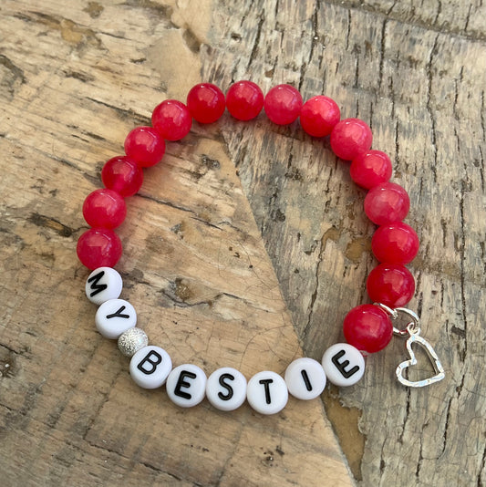 Ein pinkes Perlenarmband mit Herzanhänger 