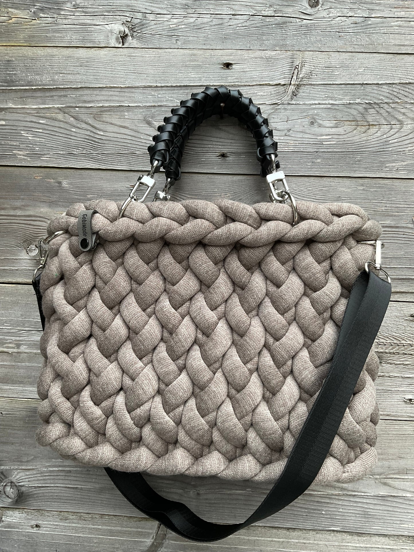 Eine gestrickte braune Tasche mit geflochtenen Griffen 