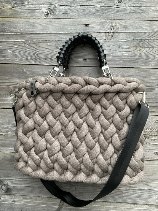 Eine gestrickte braune Tasche mit geflochtenen Griffen 
