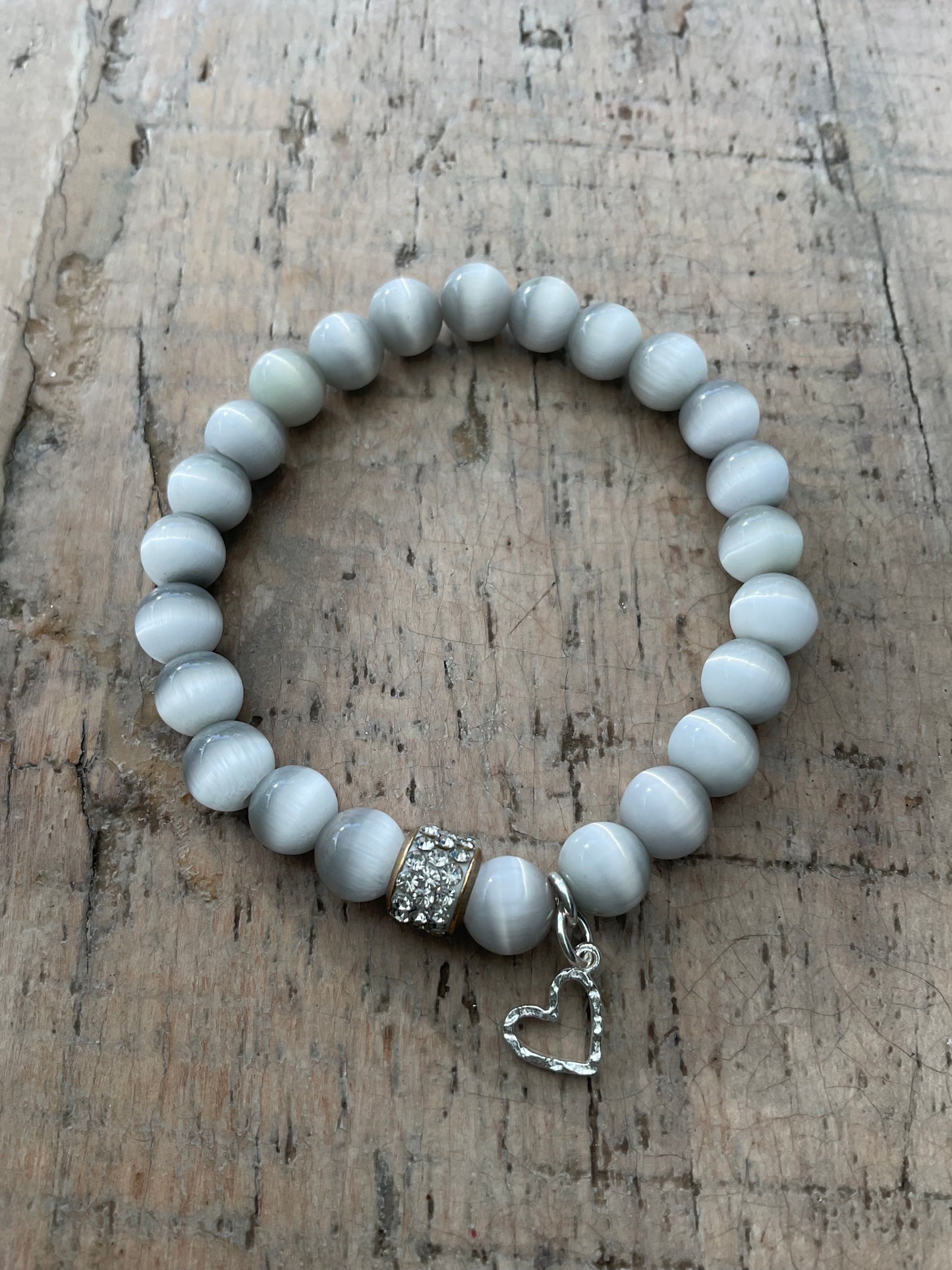 Ein graues perlenarmband mit Herzanhänger 