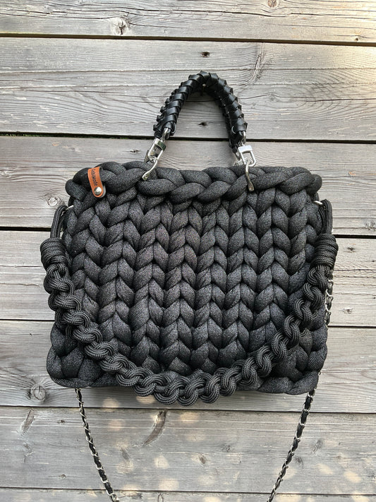 Eine gestrickte schwarze Tasche mit Lurexfäden
