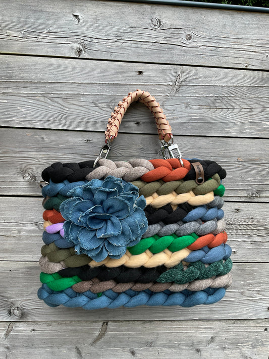 Eine gestrickte bunte Tasche mit Ledergriffen 