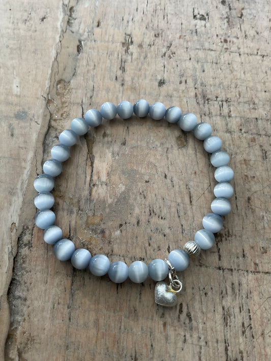 Ein graues perlenarmband mit Herzanhänger 
