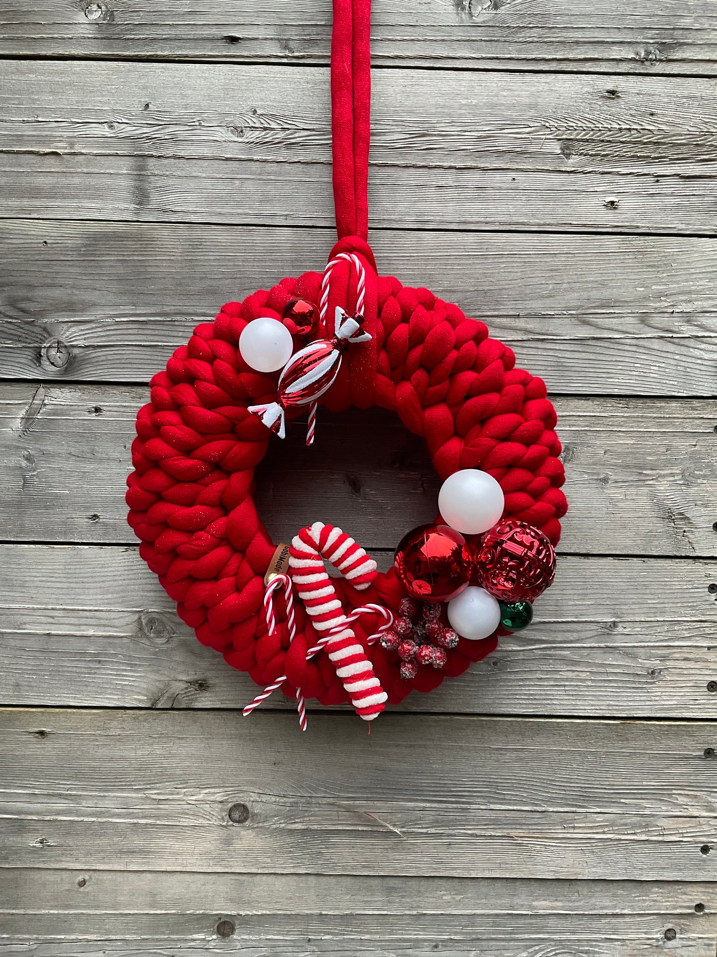 Ein roter weihnachtlich gestrickter Türkranz