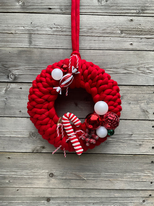 Ein roter weihnachtlich gestrickter Türkranz