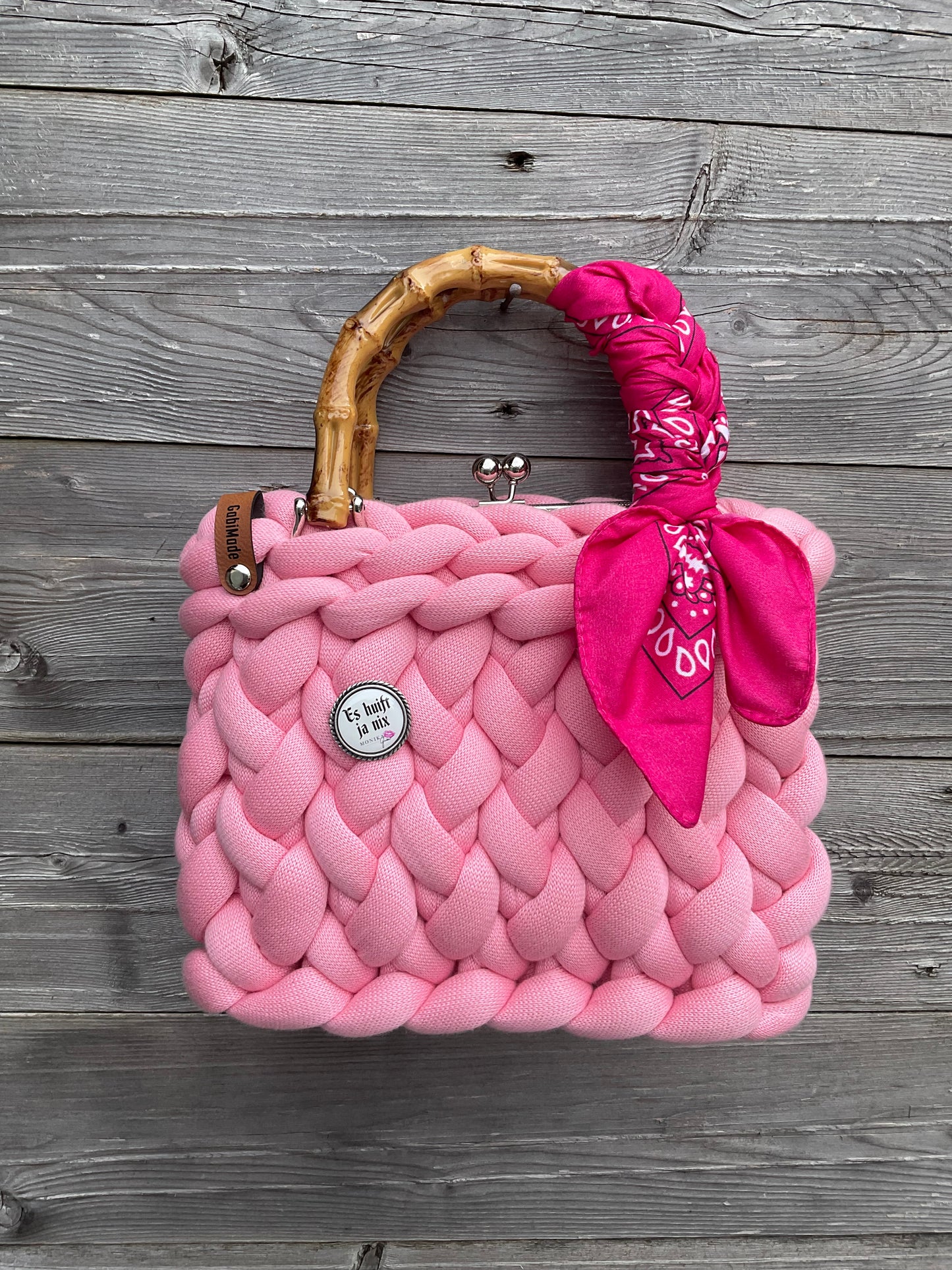 Eine gestrickte Pinke trachtentasche mit Bambusgriffen 